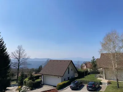 a house with two cars parked in a parking lot at Cozzy cottage near Ljubljana in Višnja Gora