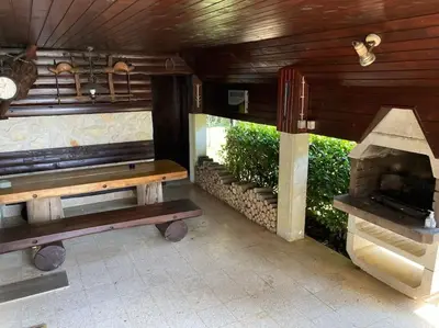 a patio with a bench and an outdoor fireplace at Cozzy cottage near Ljubljana in Višnja Gora