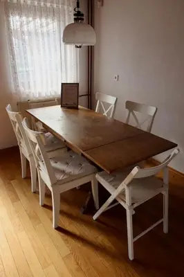 a dining room table with chairs and a laptop on it at Cozzy cottage near Ljubljana in Višnja Gora