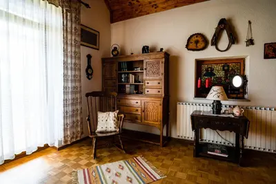 a living room with a dresser and a chair at Charming Bled Home - Big Garden, BBQ & Free Bikes in Bled