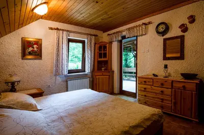 a bedroom with a bed and a dresser and a window at Charming Bled Home - Big Garden, BBQ & Free Bikes in Bled