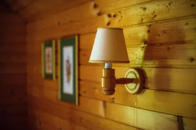 a lamp on a wooden wall with pictures at Charming Bled Home - Big Garden, BBQ & Free Bikes in Bled