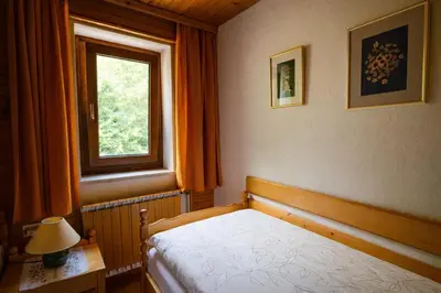 a bedroom with a bed and a window at Charming Bled Home - Big Garden, BBQ & Free Bikes in Bled
