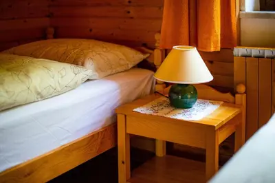 a bedroom with a bed and a lamp on a table at Charming Bled Home - Big Garden, BBQ & Free Bikes in Bled
