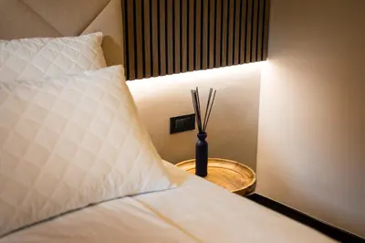 a bedroom with a bed with a lamp on a table at Villa Avrelia in Ljubljana