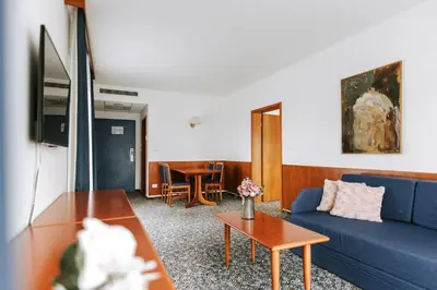 a living room with a blue couch and a table at Hotel Toplice - Terme Čatež in Čatež ob Savi