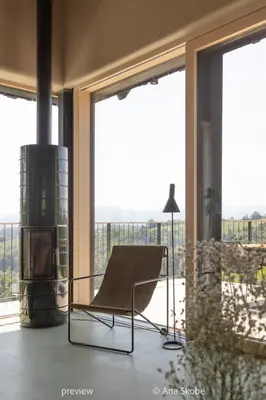 a chair in a room with large windows at Vila Slatina Weinderer in Svečina