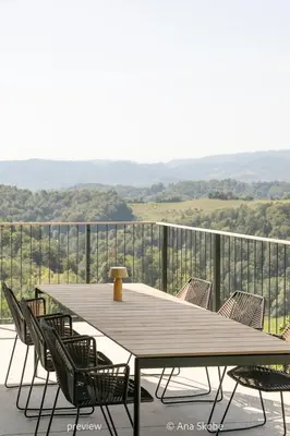 a wooden table and chairs on a balcony at Vila Slatina Weinderer in Svečina