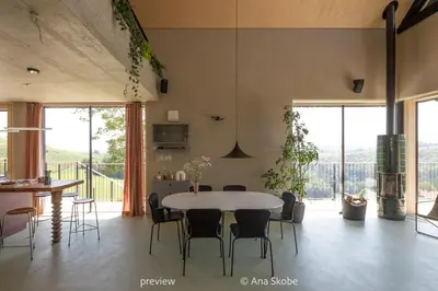 a dining room with a table and chairs and windows at Vila Slatina Weinderer in Svečina