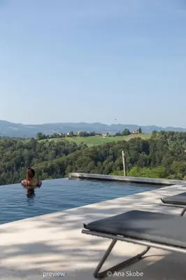 a woman swimming in a swimming pool in the water at Vila Slatina Weinderer in Svečina