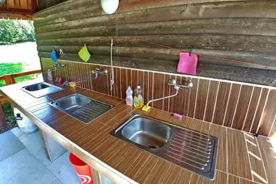 a kitchen with two sinks and a wooden counter at Camping & Glamping Jezersko ex Cvet Gora in Zgornje Jezersko