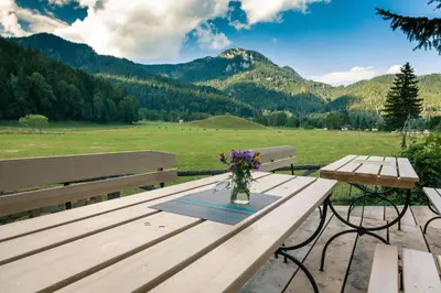 a wooden picnic table with a vase of flowers on it at Camping & Glamping Jezersko ex Cvet Gora in Zgornje Jezersko