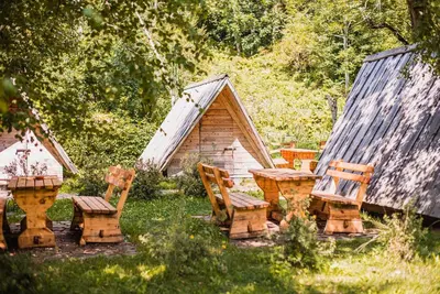 a group of chairs and a table and a cabin at Camping & Glamping Jezersko ex Cvet Gora in Zgornje Jezersko