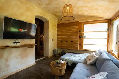 a living room with a couch and a flat screen tv at Alpine styled apartment in central BLED in Bled