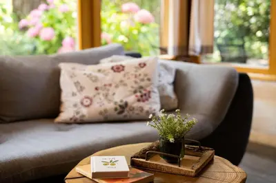 a living room with a couch and a table with flowers at Alpine styled apartment in central BLED in Bled