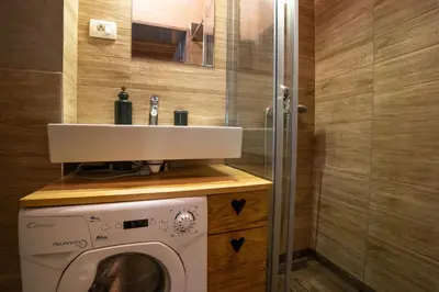 a bathroom with a washing machine and a sink at Alpine styled apartment in central BLED in Bled