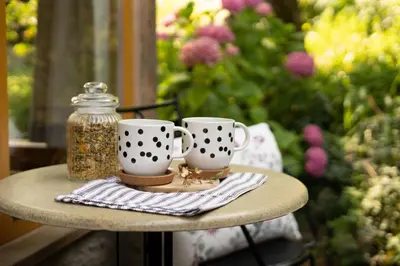 two coffee cups and a glass jar on a table at Alpine styled apartment in central BLED in Bled
