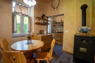 a kitchen with a wooden table and a table and chairs at Alpine styled apartment in central BLED in Bled