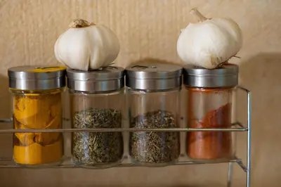 a spice rack with jars of spices and garlic at Alpine styled apartment in central BLED in Bled