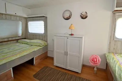a bedroom with two beds and a cabinet in it at Počitniška kamp hiška Miha, Terme 3000 - VKLJUČENI 2 KOPALNI KARTI in Moravske Toplice