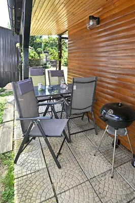 a patio with a table and chairs and a grill at Počitniška kamp hiška Miha, Terme 3000 - VKLJUČENI 2 KOPALNI KARTI in Moravske Toplice