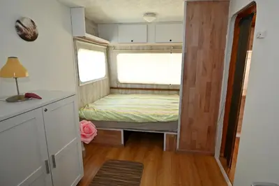 a small bedroom with a bed in a tiny house at Počitniška kamp hiška Miha, Terme 3000 - VKLJUČENI 2 KOPALNI KARTI in Moravske Toplice