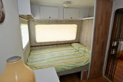 a small bed in the corner of a tiny house at Počitniška kamp hiška Miha, Terme 3000 - VKLJUČENI 2 KOPALNI KARTI in Moravske Toplice