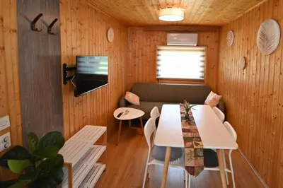 a living room with a table and a couch at Počitniška kamp hiška Miha, Terme 3000 - VKLJUČENI 2 KOPALNI KARTI in Moravske Toplice