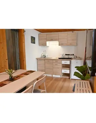 a kitchen with a table and a counter top at Počitniška kamp hiška Miha, Terme 3000 - VKLJUČENI 2 KOPALNI KARTI in Moravske Toplice
