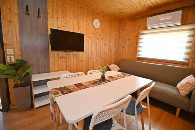 a living room with a white table and a couch at Počitniška kamp hiška Miha, Terme 3000 - VKLJUČENI 2 KOPALNI KARTI in Moravske Toplice