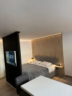 a small bedroom with a bed and a tv at Suite Appartments Gregorčičeva in Ljubljana