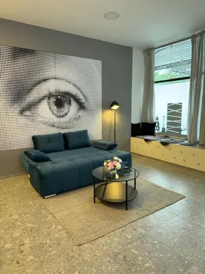 a living room with a blue couch and a table at Suite Appartments Gregorčičeva in Ljubljana