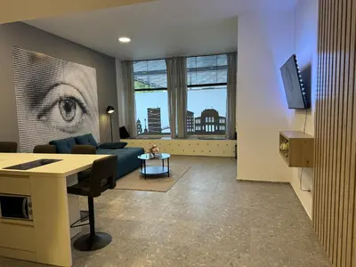 a living room with a blue couch and a tv at Suite Appartments Gregorčičeva in Ljubljana