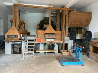 a room with wooden furniture and a ladder and a stove at Moulin a Vipava in Renče