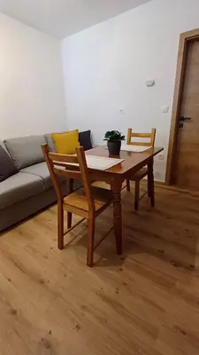 a table and chairs in a living room with a couch at Apartment HANI in Kranjska Gora