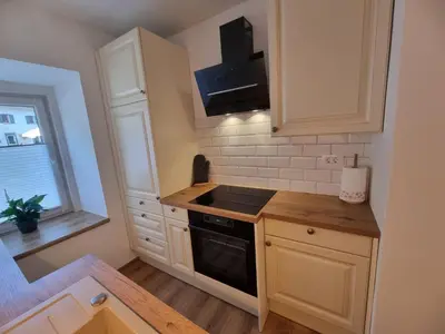 a kitchen with white cabinets and a black stove top oven at Apartment HANI in Kranjska Gora