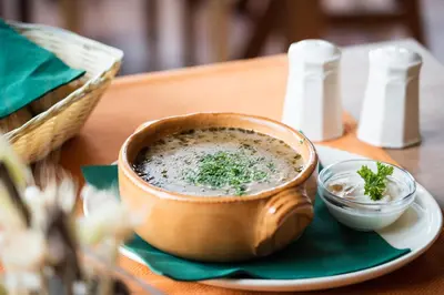 a bowl of soup on a plate on a table at Hotel Tisa Pohorje in Pohorje