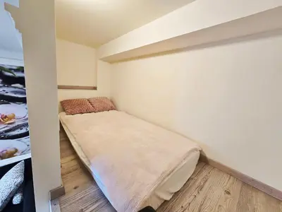 a small bedroom with a bed in the corner at Apartments Rubis in Stožice