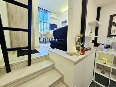 a living room with stairs leading into a living room at Apartments Rubis in Stožice