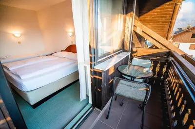a balcony with a bed and a table and a chair at Guesthouse Leski Dvor in Lesce