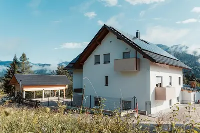 a white house with a brown roof at Apartmaji Laznik in Ljubno