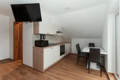 a small kitchen with a table and a dining room at Apartmaji Laznik in Ljubno