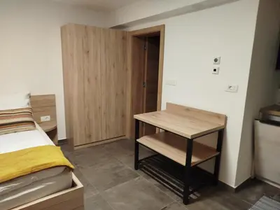 a bedroom with a bed and a desk in it at Apartma Mamut 1850 in Kamnik