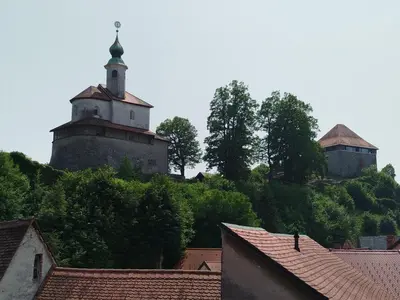 two towers on top of a hill with roofs at Apartma Mamut 1850 in Kamnik