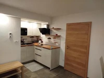 a small kitchen with a wooden door in a room at Apartma Mamut 1850 in Kamnik