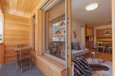 a room with wooden walls and a large window in a house at Goldhorn Chalet SKI IN&OUT in Kranjska Gora
