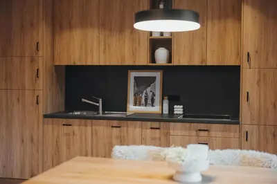 a kitchen with a sink and a table with a lamp at Goldhorn Chalet SKI IN&OUT in Kranjska Gora
