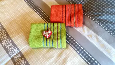 two towels with a heart on them on a table at Ethno Apartments in Ljubljana