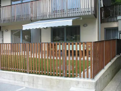 a wooden fence in front of a house at Apartma Jeglic in Bohinj