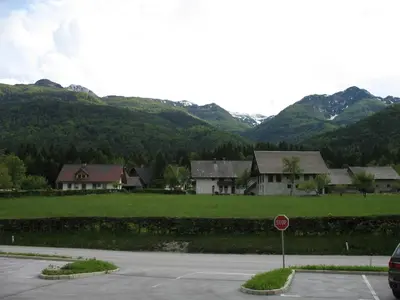 a stop sign in front of some houses with mountains at Apartma Jeglic in Bohinj